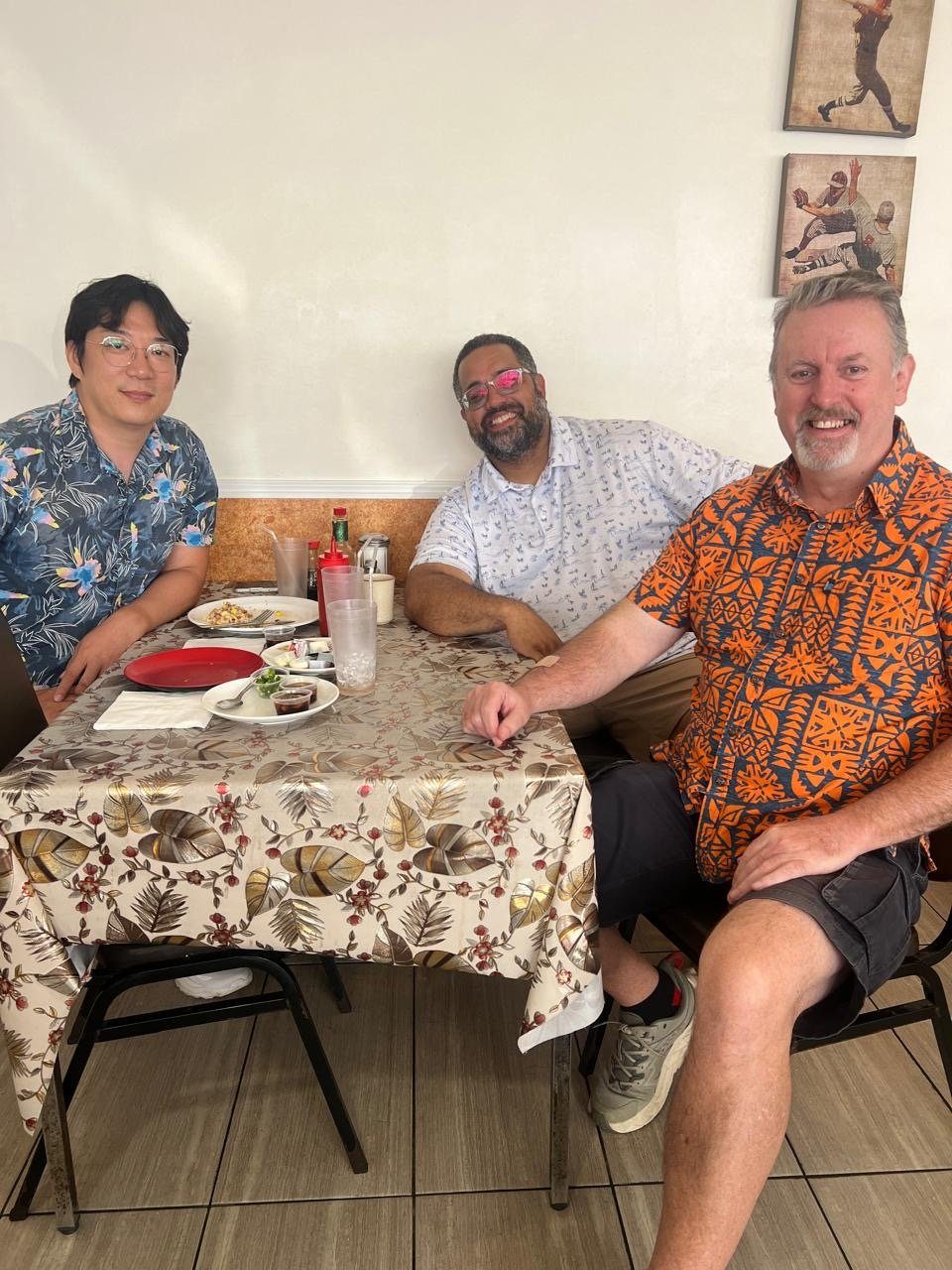 Eric Ji at a restaurant table with David, the IFES Pacific regional director, and one companion