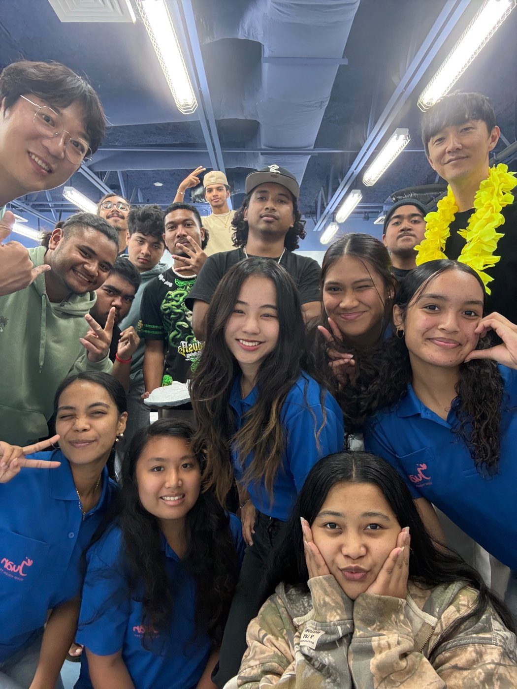 A group selfie of Eric Ji with HisPlan Movement students in blue polo shirts